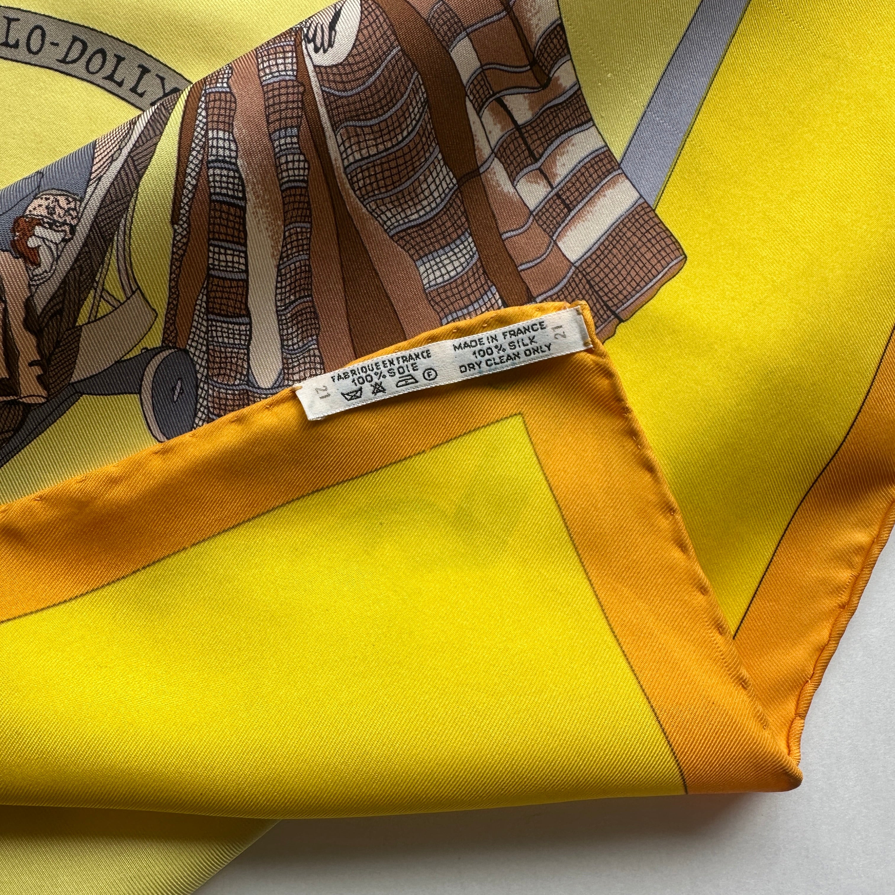 Étiquette de composition "Made in France 100% Silk" cousue sur l'ourlet roulotté orange (tampon S discret).