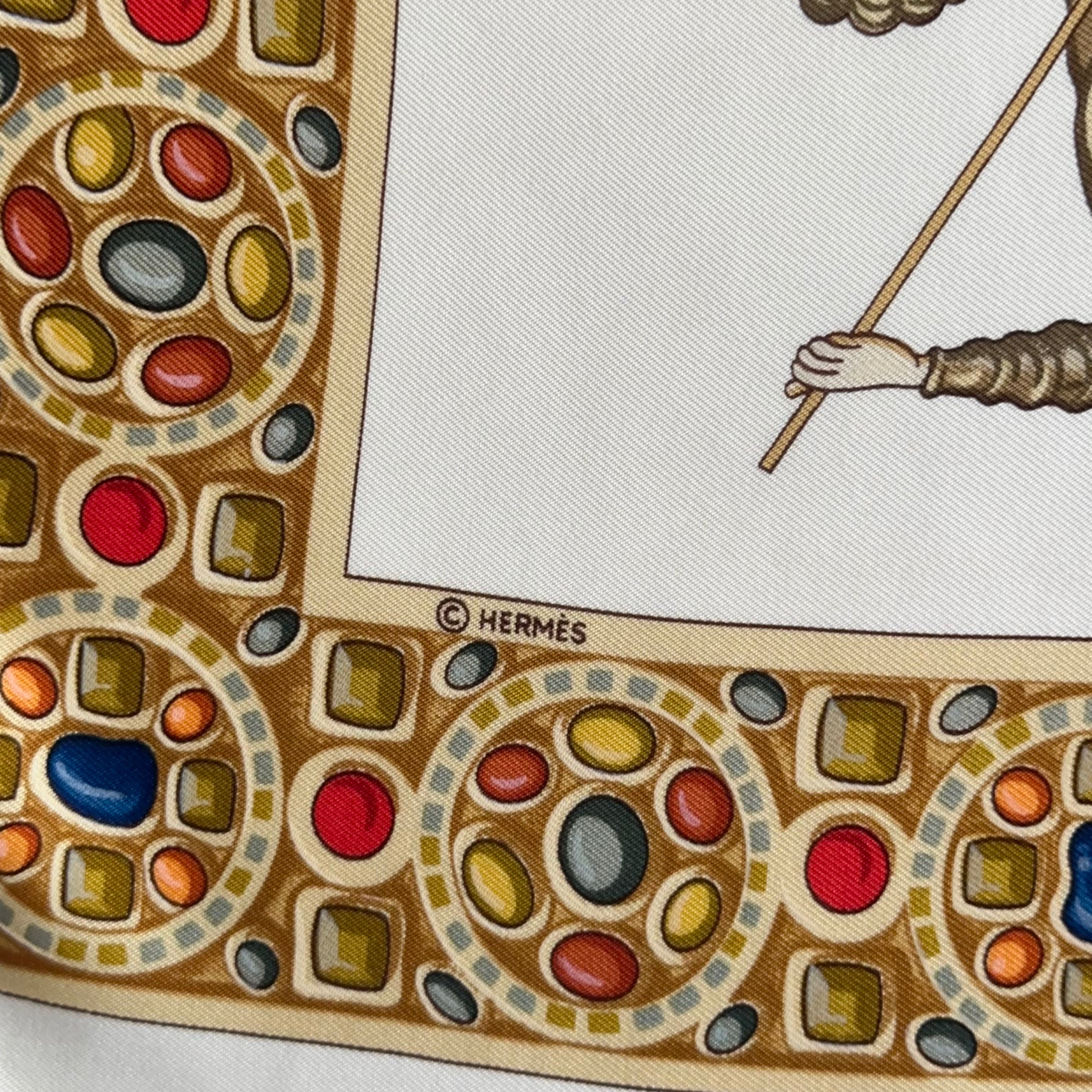 Détail de la bordure du foulard montrant le copyright "© HERMÈS" et la richesse du motif de cadre orfévré serti de pierres colorées.