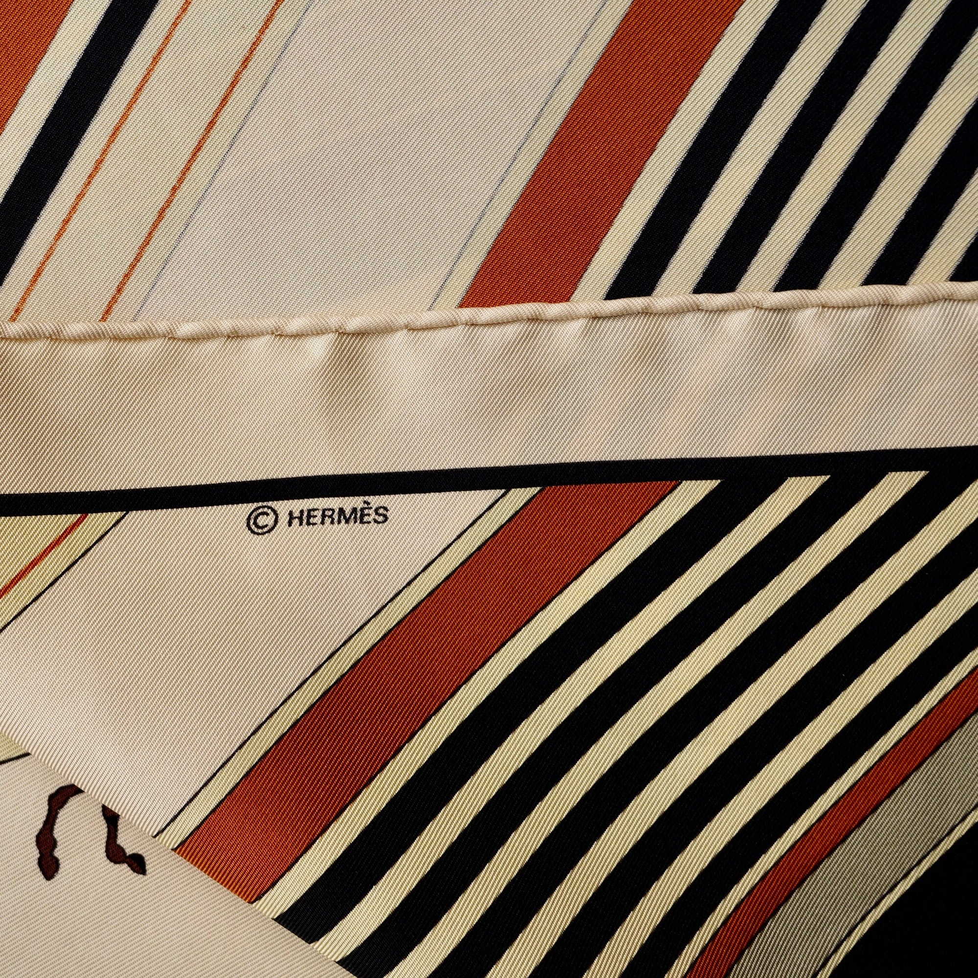 Détail de la bordure ocre et crème avec le logo de copyright © HERMÈS imprimé.