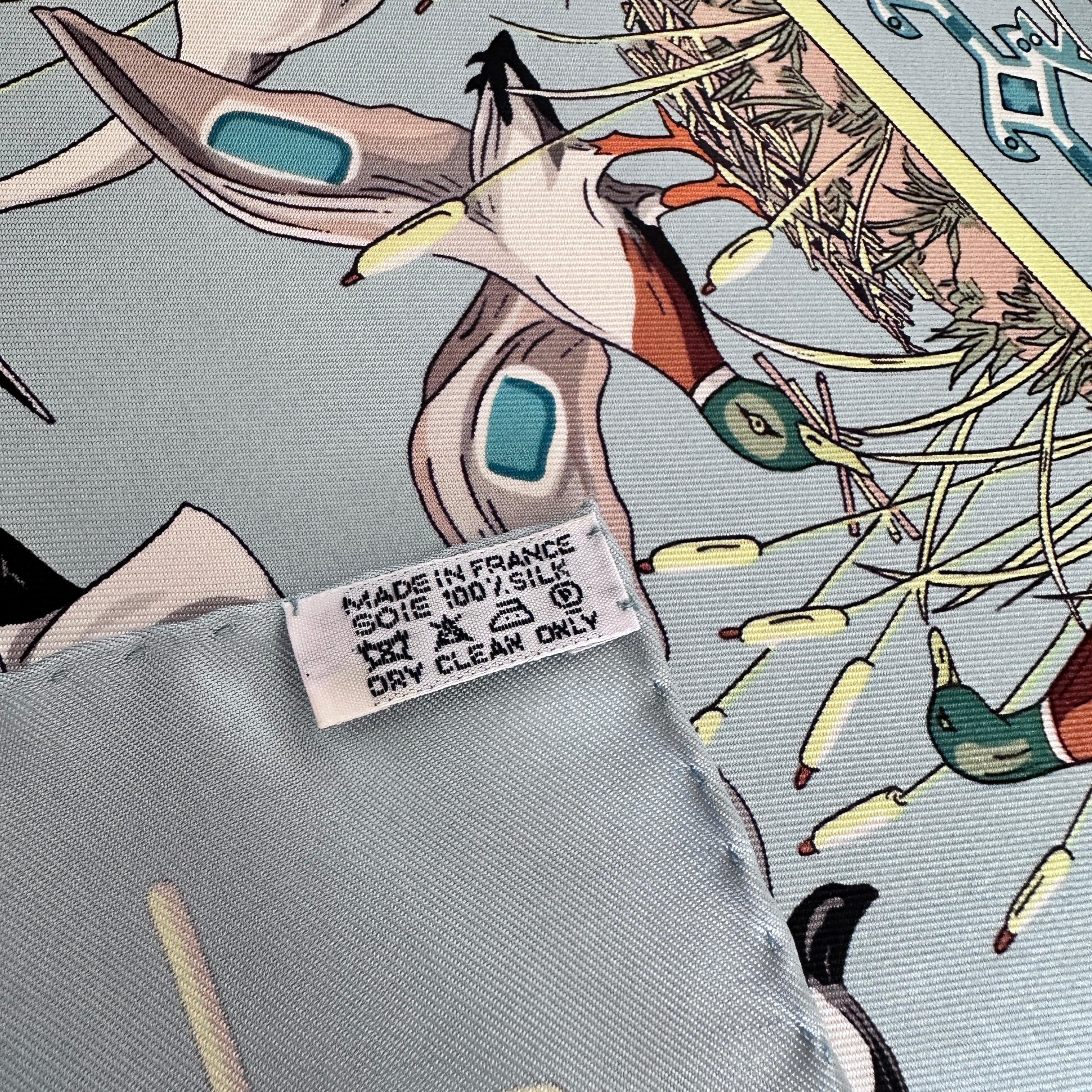 Étiquette de composition soie Made in France et détail des motifs d'oiseaux.