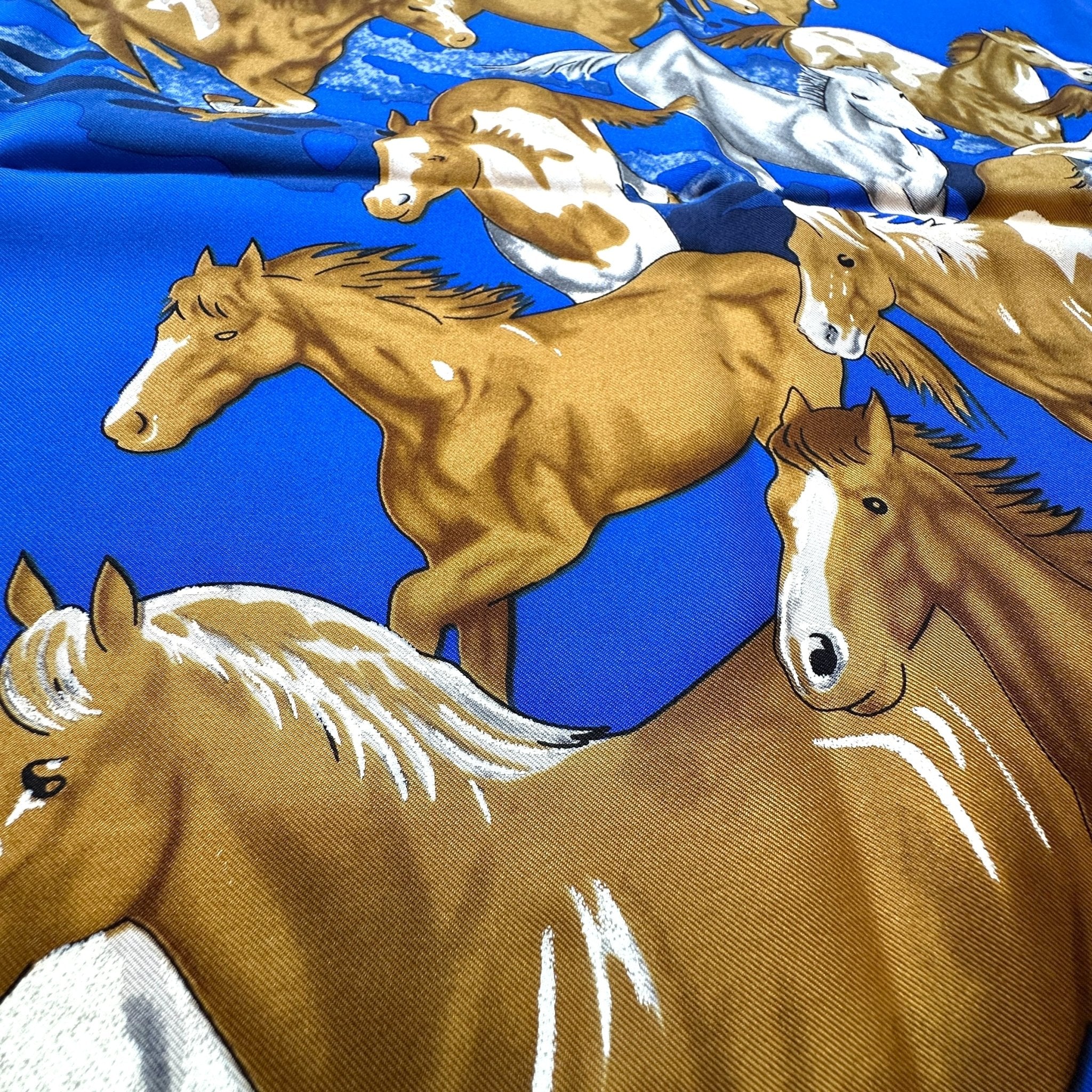 zoom sur le dessin d'un groupe de chevaux courant sur fond bleu