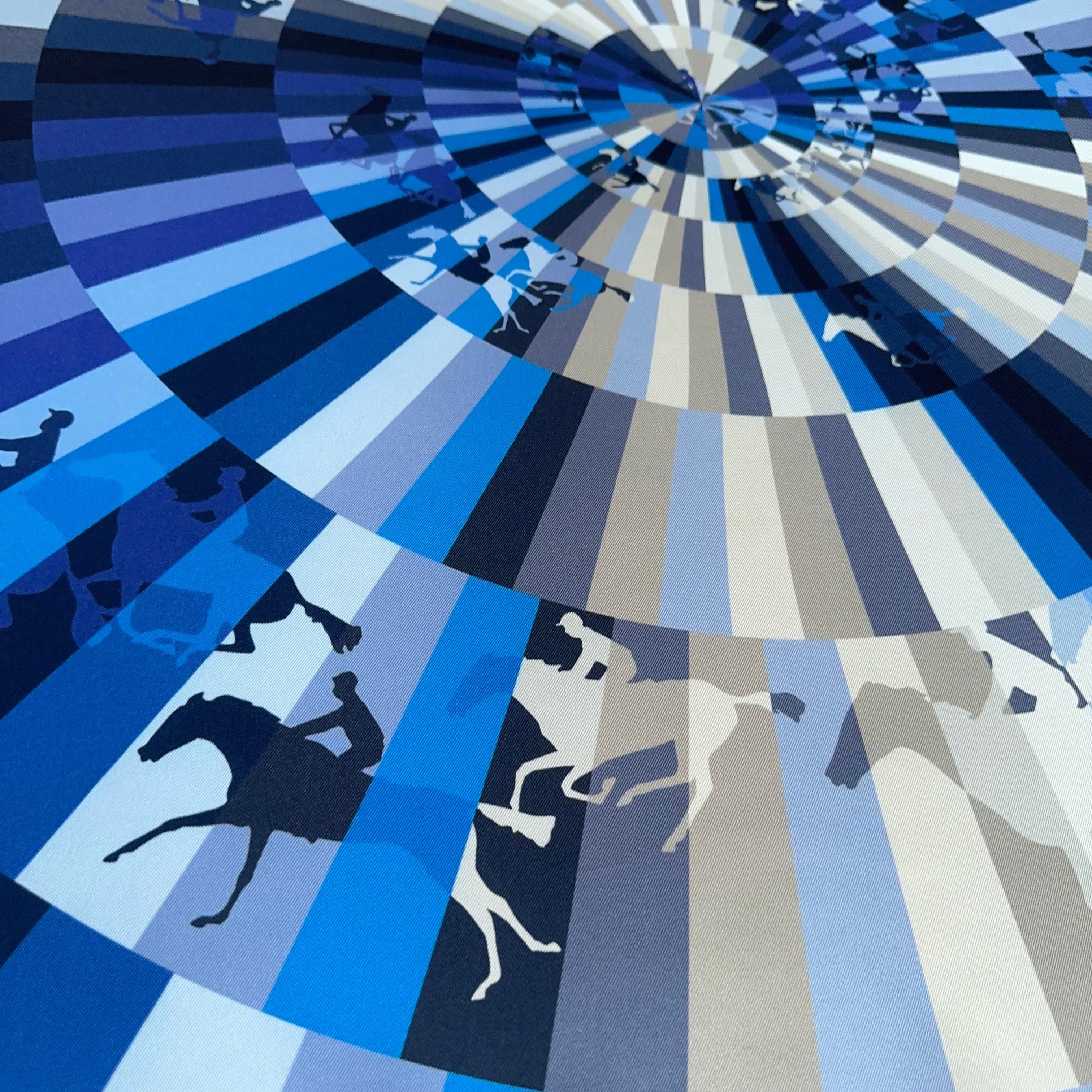 Vue en perspective du foulard montrant l'effet d'optique des faisceaux de couleurs bleues rayonnant depuis le centre vers les silhouettes de chevaux.