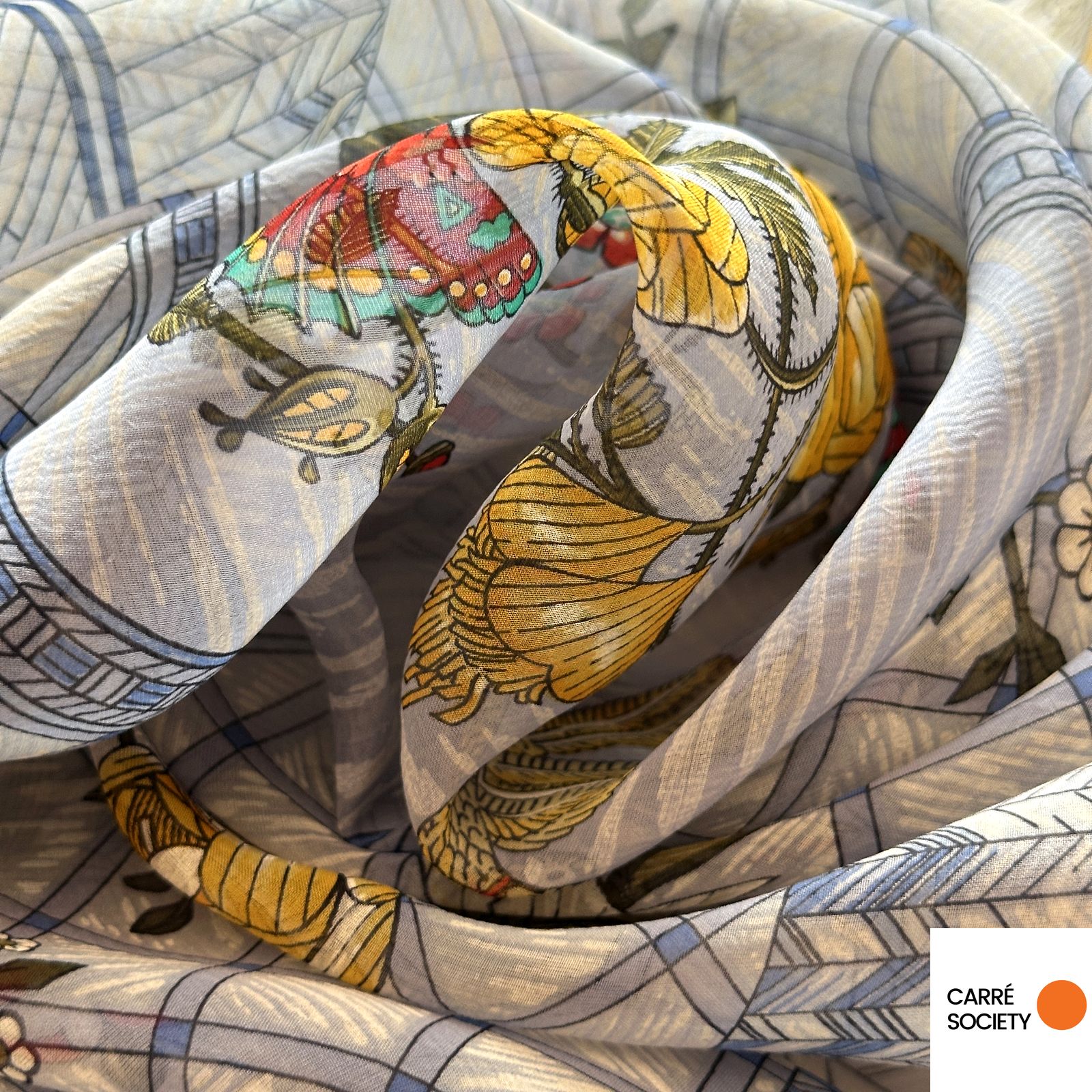 Vue rapprochée du tissu du carré Hermès Jeux de Paille révélant la transparence et les nuances du voile de soie